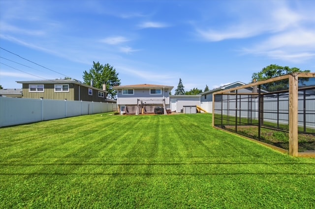 Backyard view toward rear of house with striped lawn