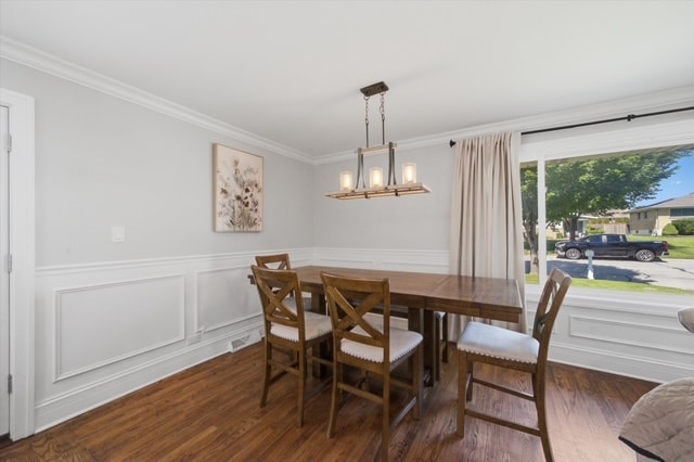 Dining room with wainscoting, chandelier and wood table